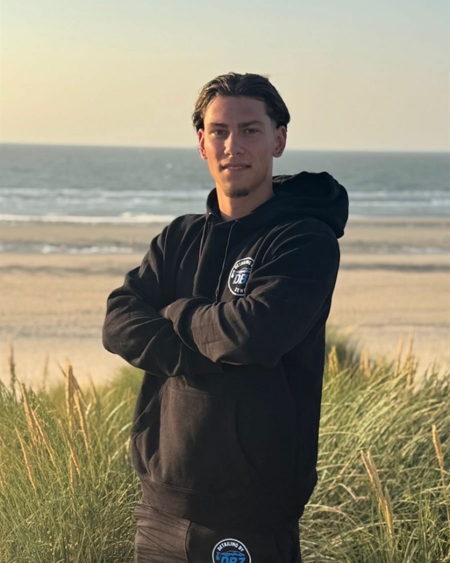 Renzo Bongers, mede-oprichter van Detailing by Zeno, aan de kust in DBZ-hoodie
